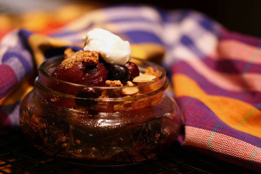 stone fruit crumble in a mason jar with a plaid towel