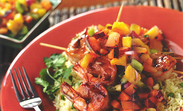 Skewers of plum glazed shrimp on rice