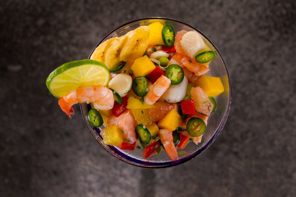 Island Ceviche overhead shot in a margarita glass with lime slice and plantain chips