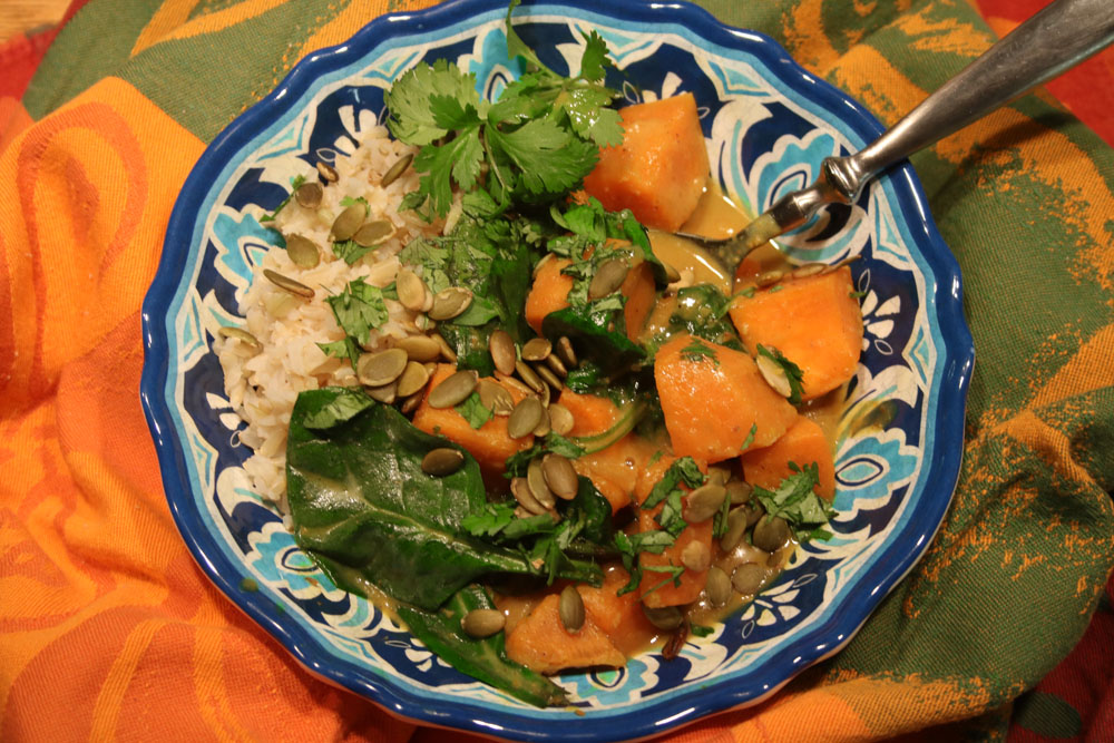 Coconut Turmeric Curry with Winter Vegetables on rice in a blue bowl