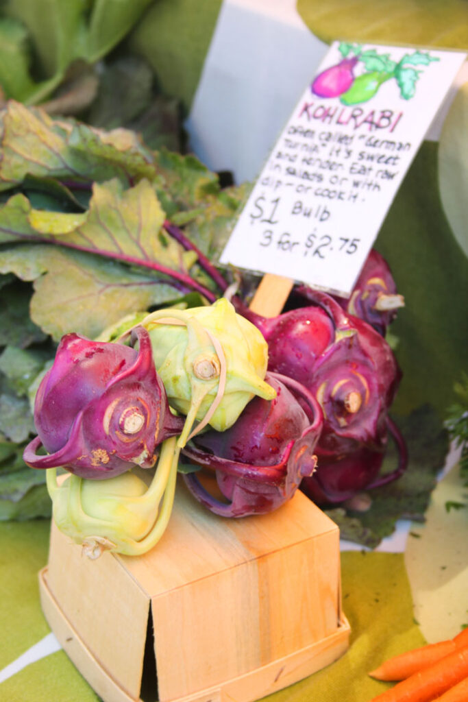 Kolorful Kohlrabi - green and purple on a wooden basket at the market
