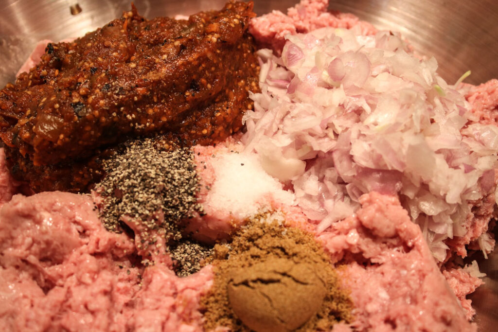 Making turkey burgers: ground turkey, cumin, pepper, salt, chopped shallots and drained salsa