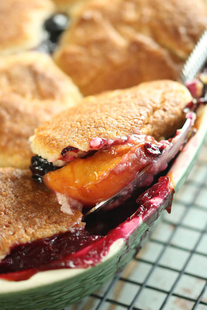 Spoonful of Nectarine and Blueberry Pot Pie in casserole on rack