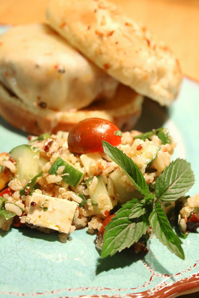 Burger and a Salad - a Greek Salad with Quinoa on a blue plate with fresh mint