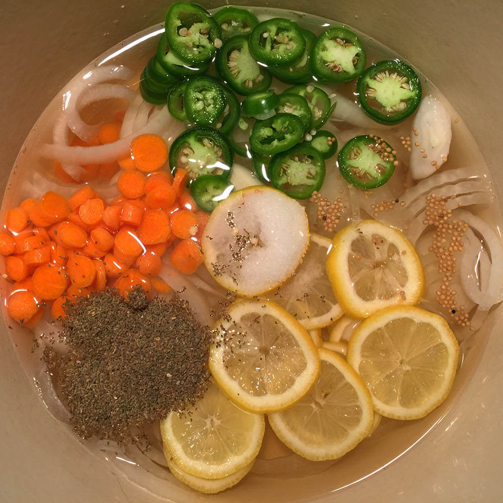 Making the Brine for pickled shrimp: vinegar, carrot slices, onions, jalapenos, lemon slices, mustard seed and celery seed