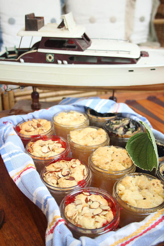 Red White & Blueberry cobblers in mason jars with a model boat behind