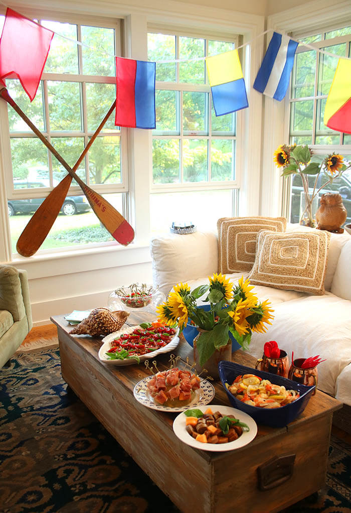 Setting Sail - Nautical potlucky with oars, flags, lots of food and a pitcher of sunflowers on the porch