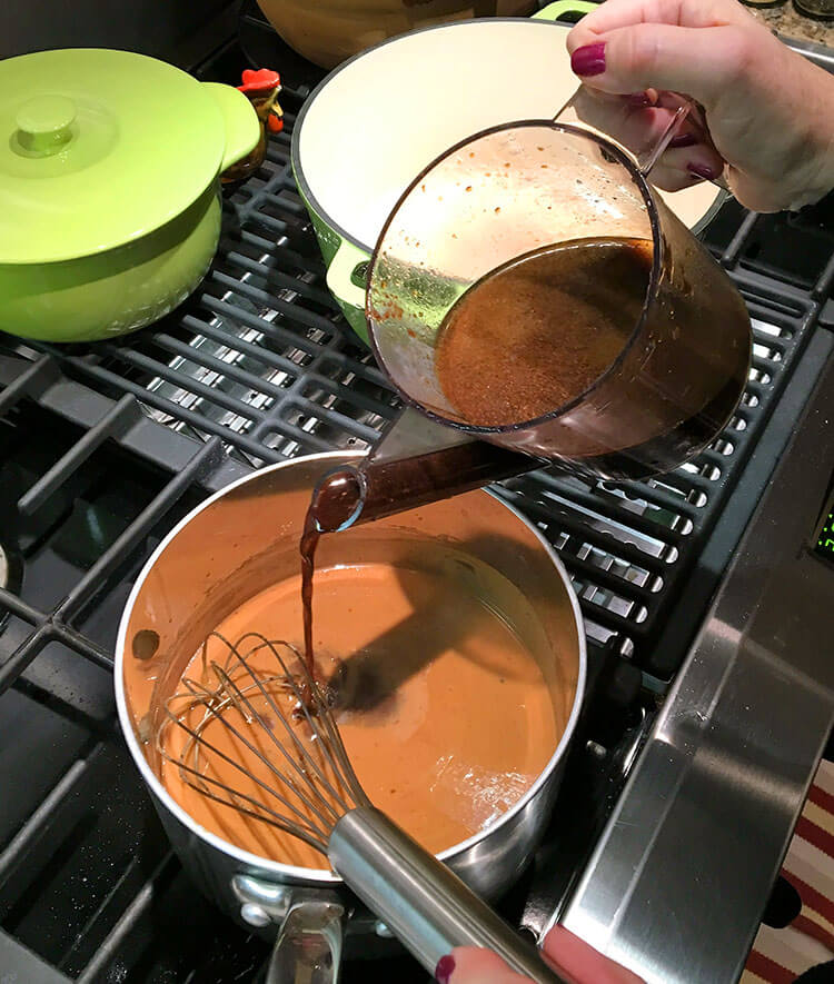 Making the gimme more gravy using a fat separator measuring cup and pouring into pan with a whisk