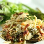 Heaping Helping turkey tetrazzini on a square white plate with a salad