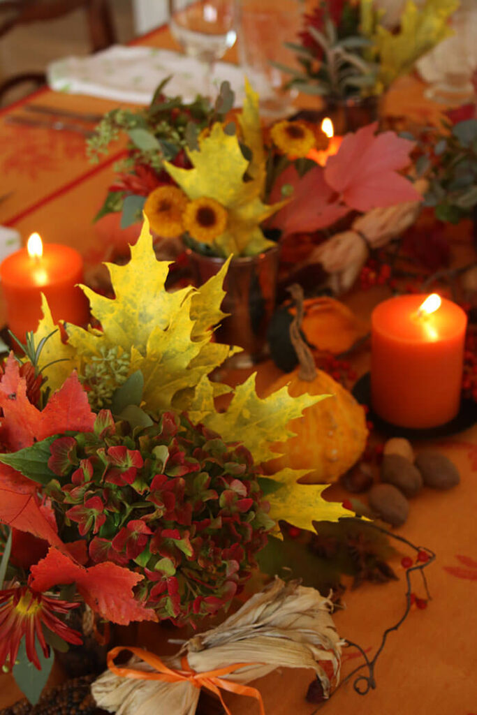 Setting The Table with fall foliage and candles on an orange cloth