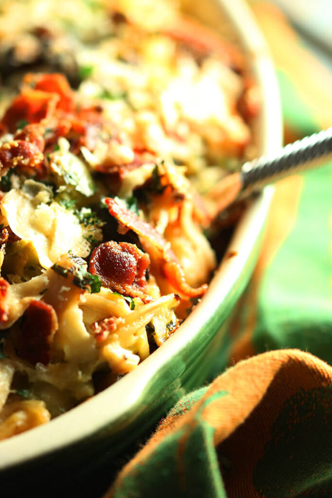 Heaping Spoonful of turkey tetrazzini in an oval casserole - topped with bacon