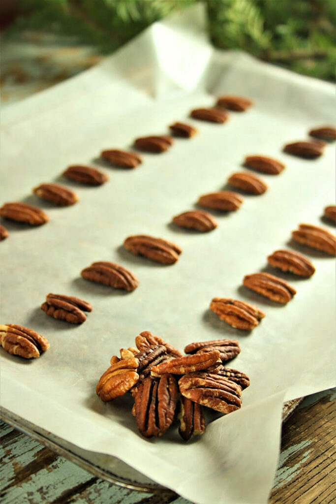 Rows of Pecans on parchment paper, ready for the hot toffee