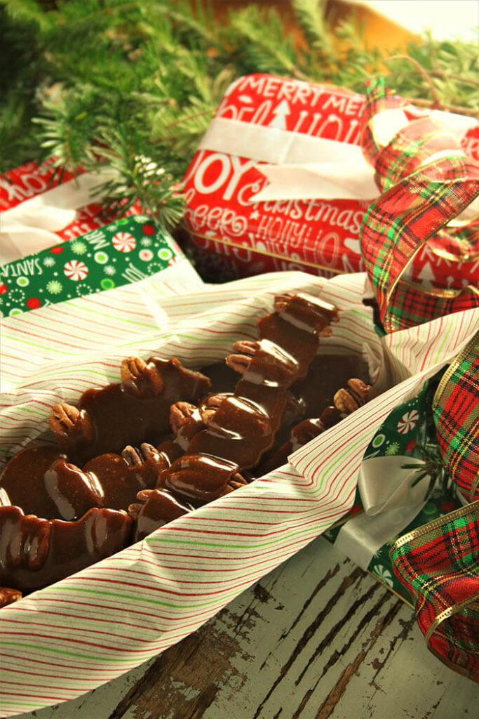 Toffee in a tin with christmas ribbons and evergreen