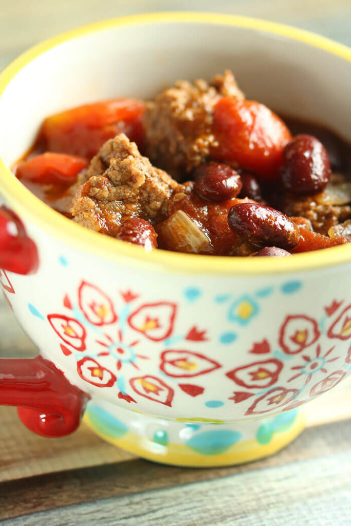 Cup of Chili topped with kidney beans and tomatoes