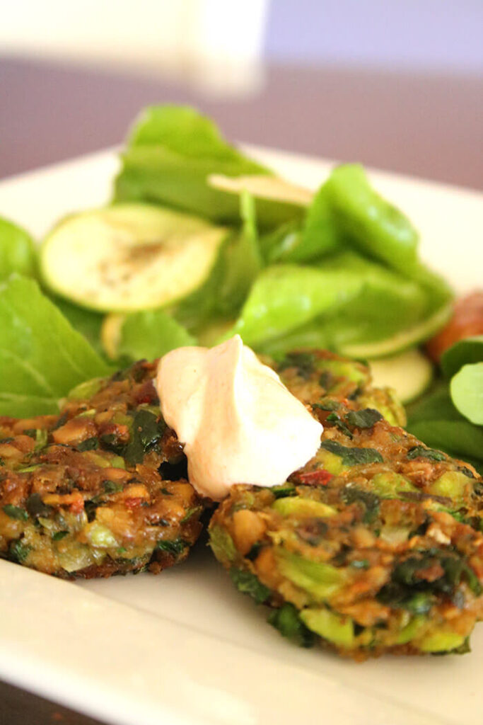 Edamame & Chickpea Fritters with chili dipping sauce and arugula and zucchini salad