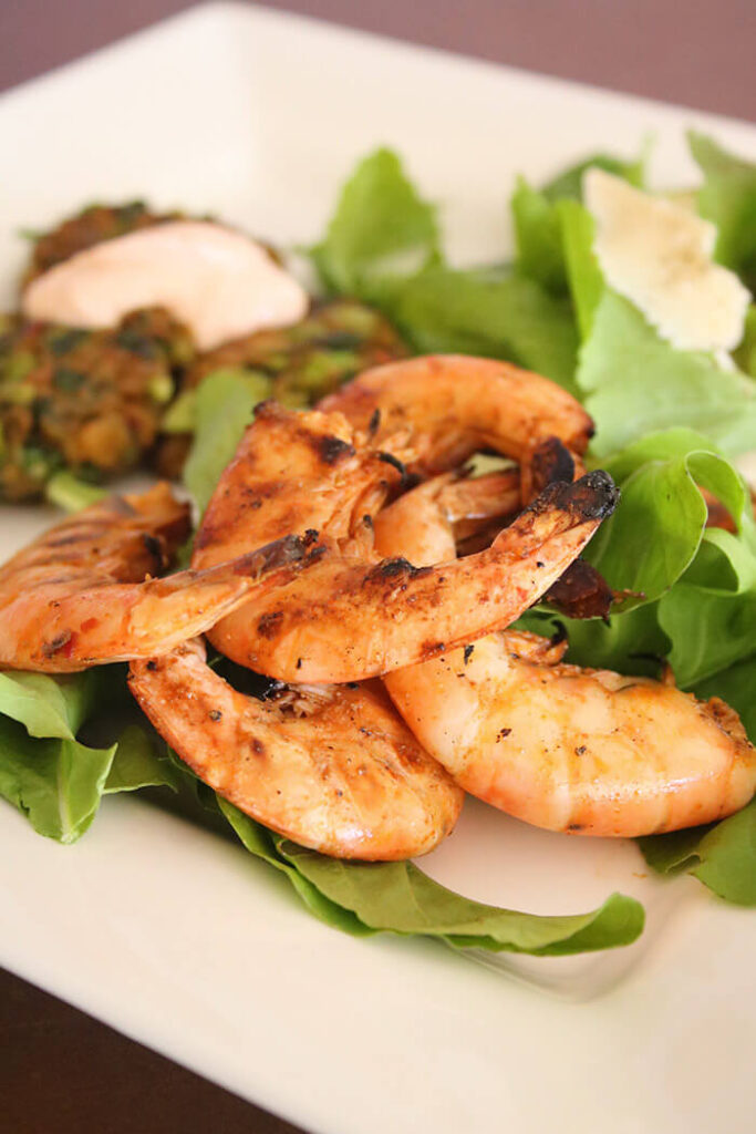 Salt and Pepper Grilled Shrimp on arugula with edamame fritter and chipotle aioli