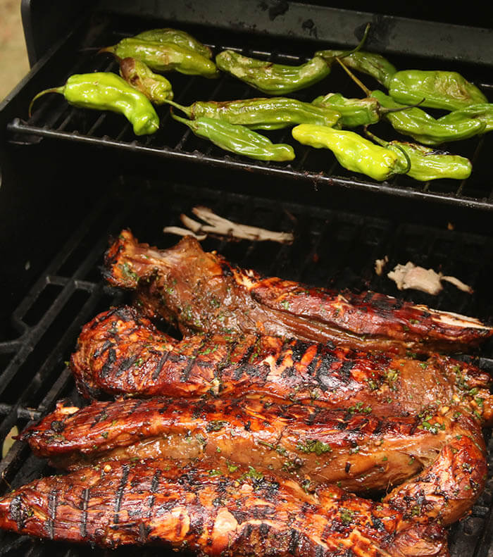 Asian Marinated Pork on the grill with shishito pepper above