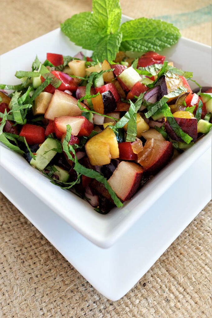 Ginger Plum Salsa with fresh mint in a square white bowl on a square white plate