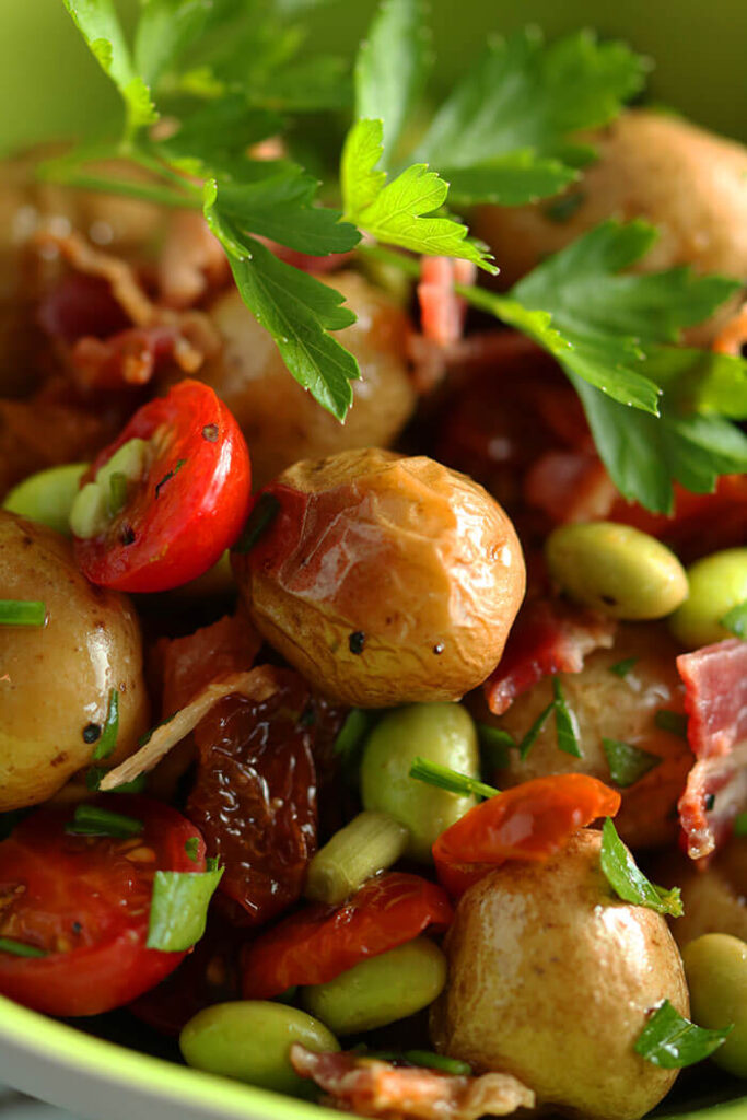 Close Up of Roasted Potato Salad with tomatoes, oven dried tomatoes, bacon and edamame
