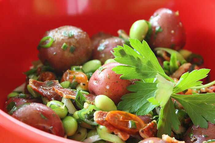 Close Up of Roasted Potato Salad with tomatoes, oven dried tomatoes, bacon and edamame