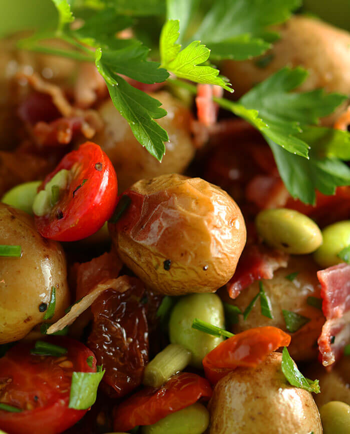 Close Up of Roasted Potato Salad with tomatoes, oven dried tomatoes, bacon and edamame