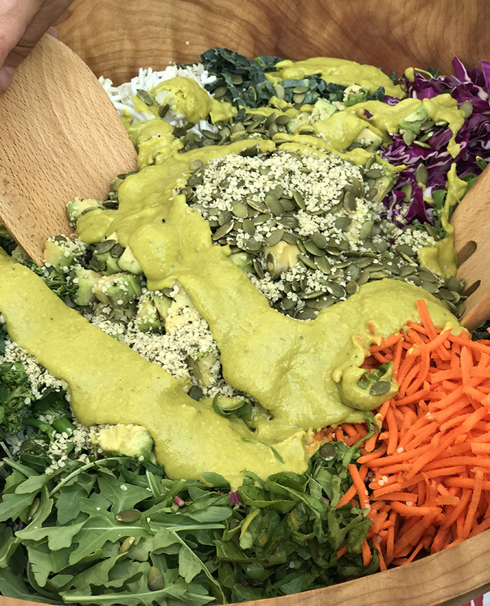 Curried Avo Dressing with Super Greens: arugula, cabbage, shredded carrots with hemp hearts and pumpkin seeds