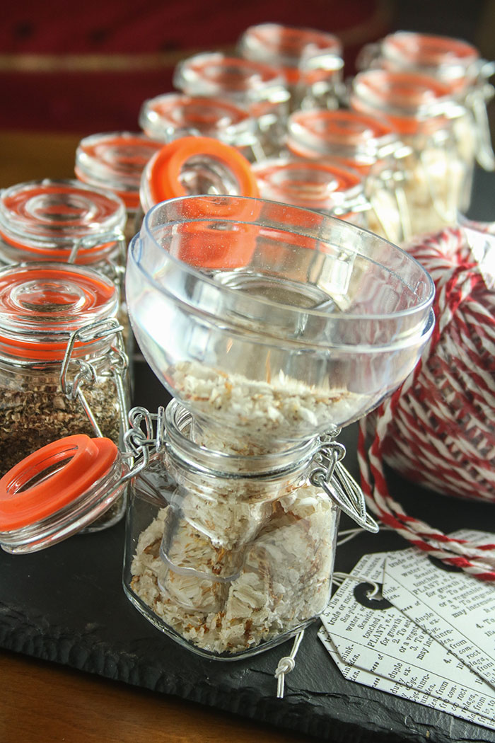 Filling the Spice Jars: rows of flip lid jars being filled with a funnel, tags, twine