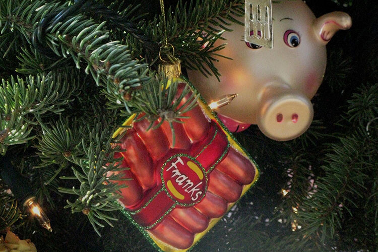 Christmas tree ornaments: a pig looking at a pack of hot dogs