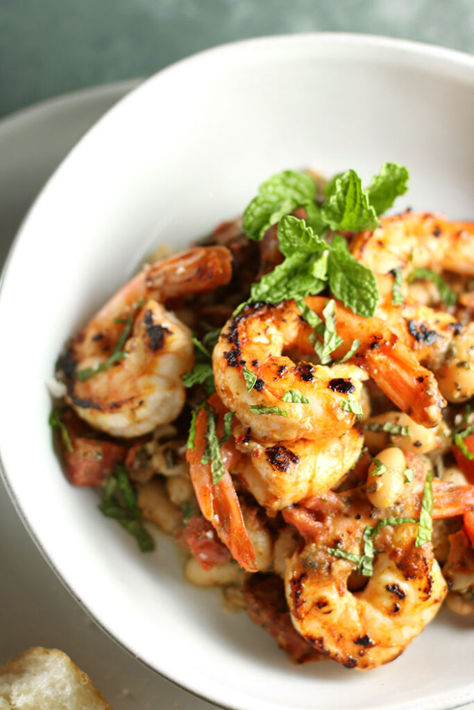 Shrimp and White Beans with Roasted Garlic & Mint in a white bowl