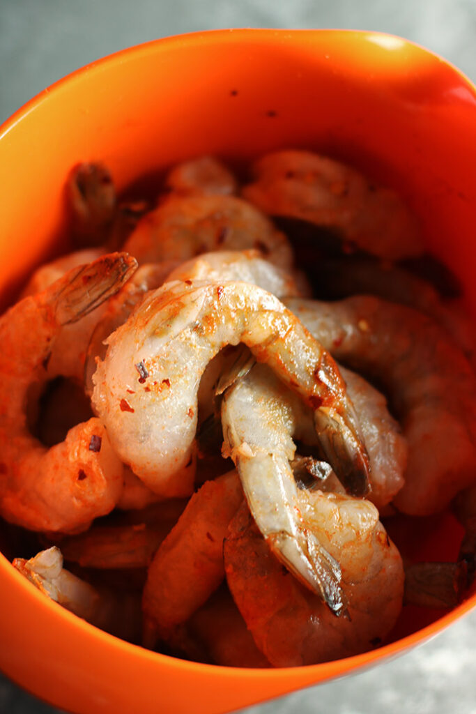 marinating shrimp in an orange bowl