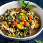 Healthy Vegetable Soup: white bowl with edamame, chicken, carrots, peppers, corn, zucchini and pesto
