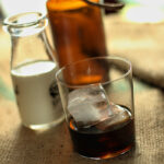 Making a Kahlua and Cream Cocktail with kahlua on the rocks in a glass and a milk bottle