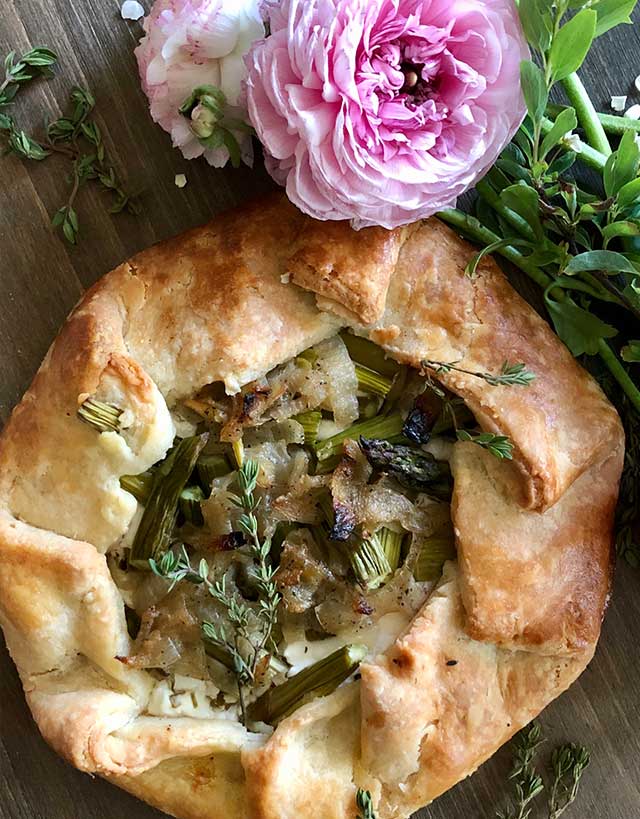 Pastry galette filled with leeks, goat cheese and thyme with pink runuculus flower