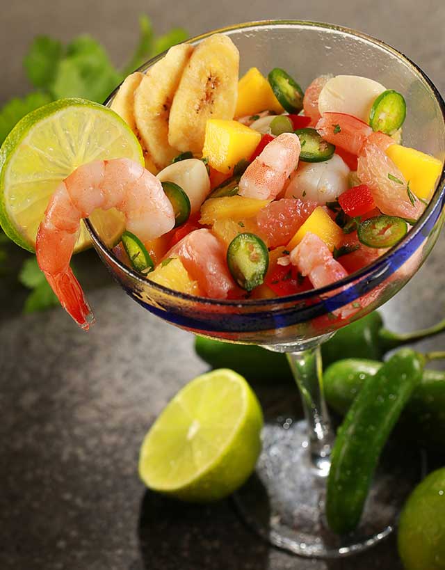 Margarita glass with shrimp ceviche with mango, grapefruit , jalapanos and plantain chips, garnished with lime