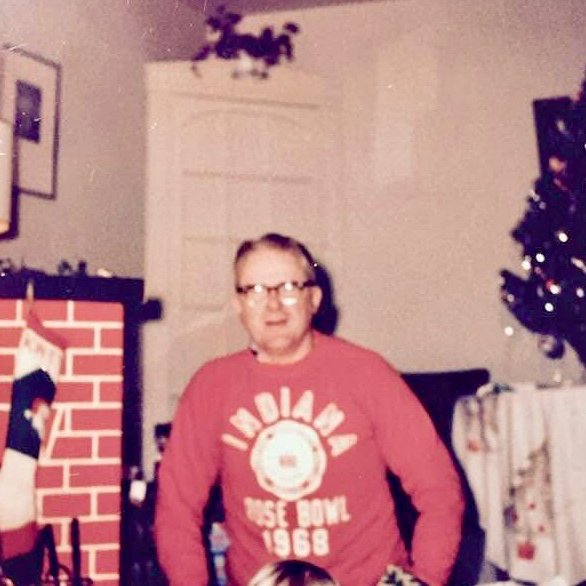 Bill Keck wearing a 1968 Indiana Rsoe Bowl Shirt by Christmas tree. Their first trip to the Rose Bowl